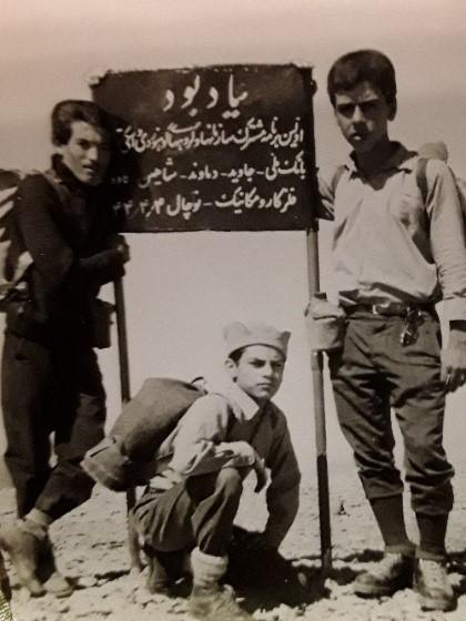 محسن رشیدی نشسته در میان عکس